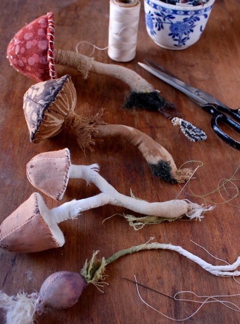 several different types of mushrooms on a table with scissors and spools of thread