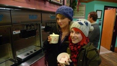 two women standing next to each other holding cups