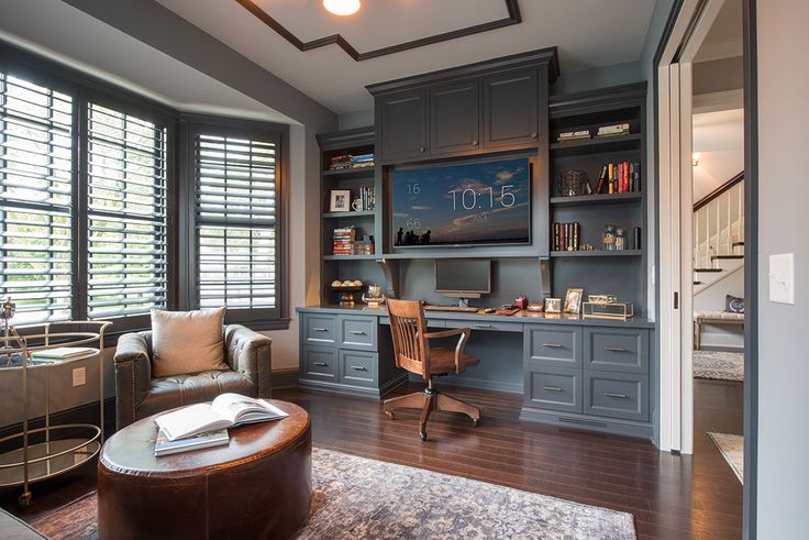 a home office with built - in desk and bookcases