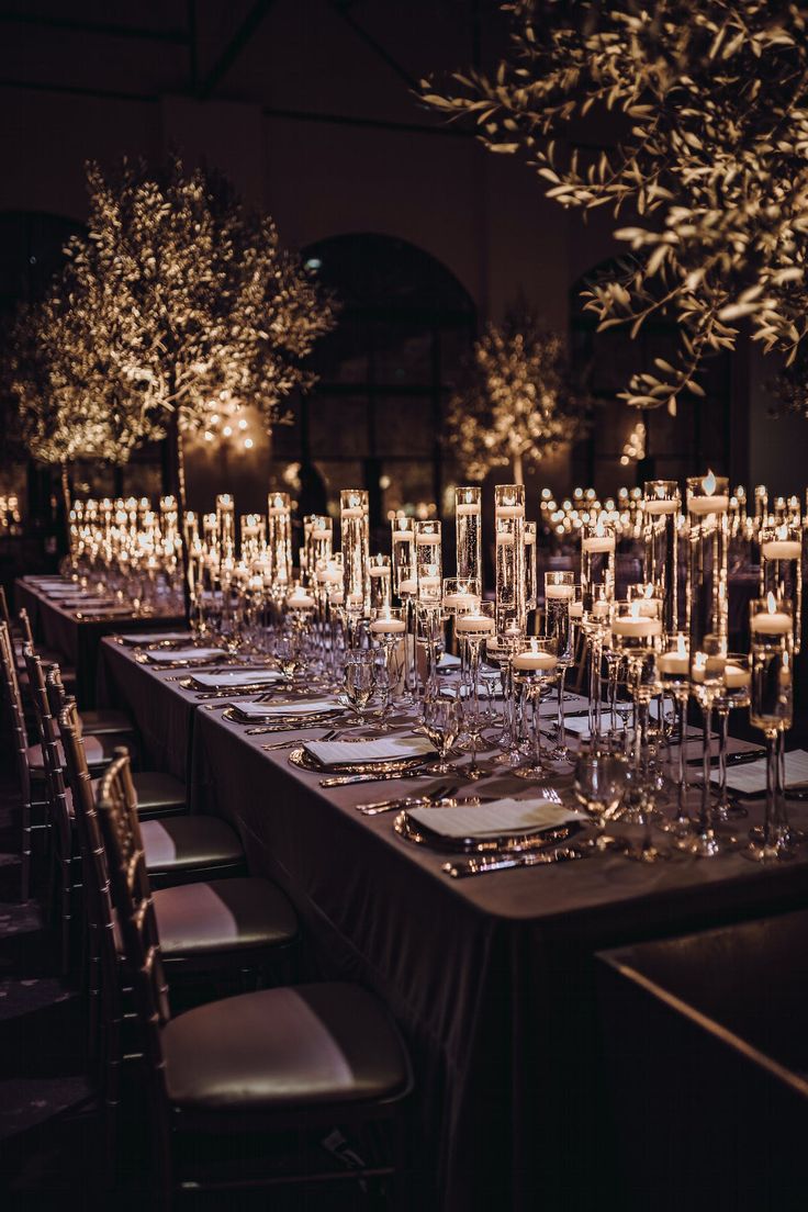 a long table is set up with candles and place settings for an elegant dinner party