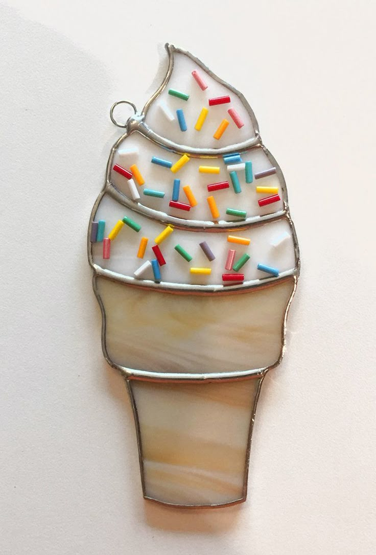 an ice cream sundae with sprinkles on it is hanging from a chain