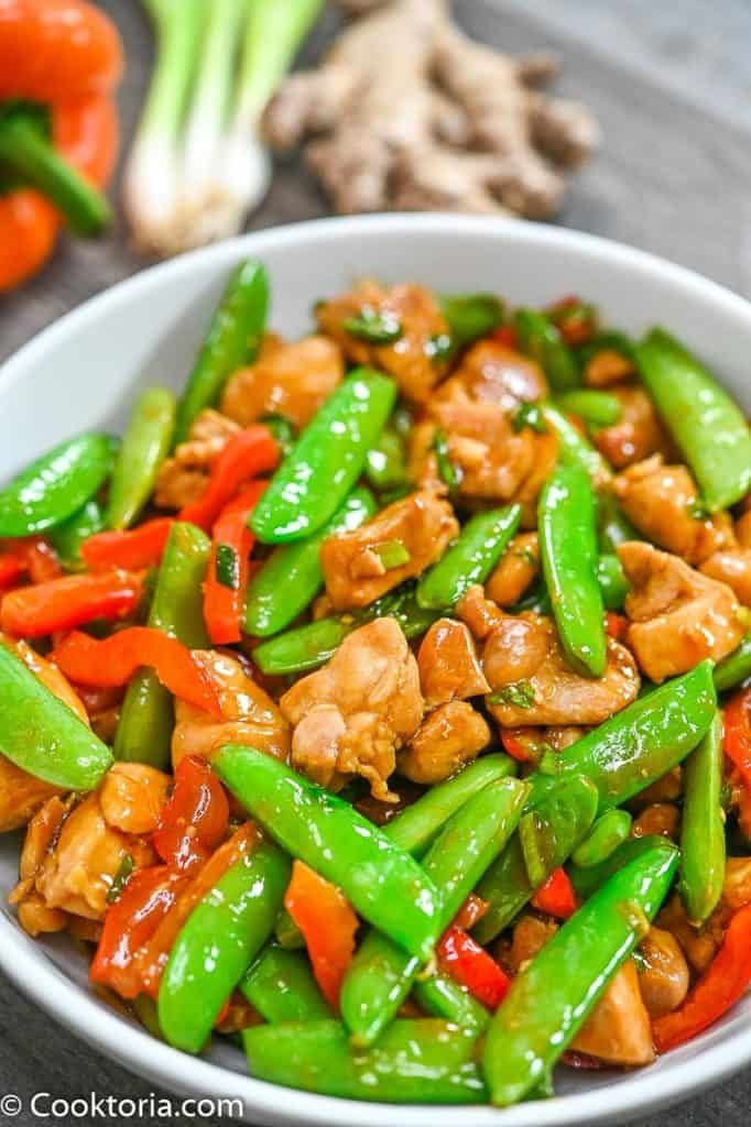 a white bowl filled with chicken and veggies