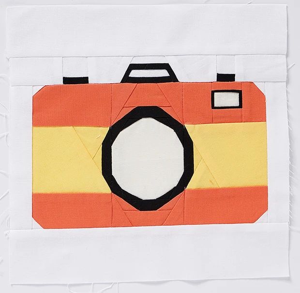 an orange and yellow camera on a piece of paper