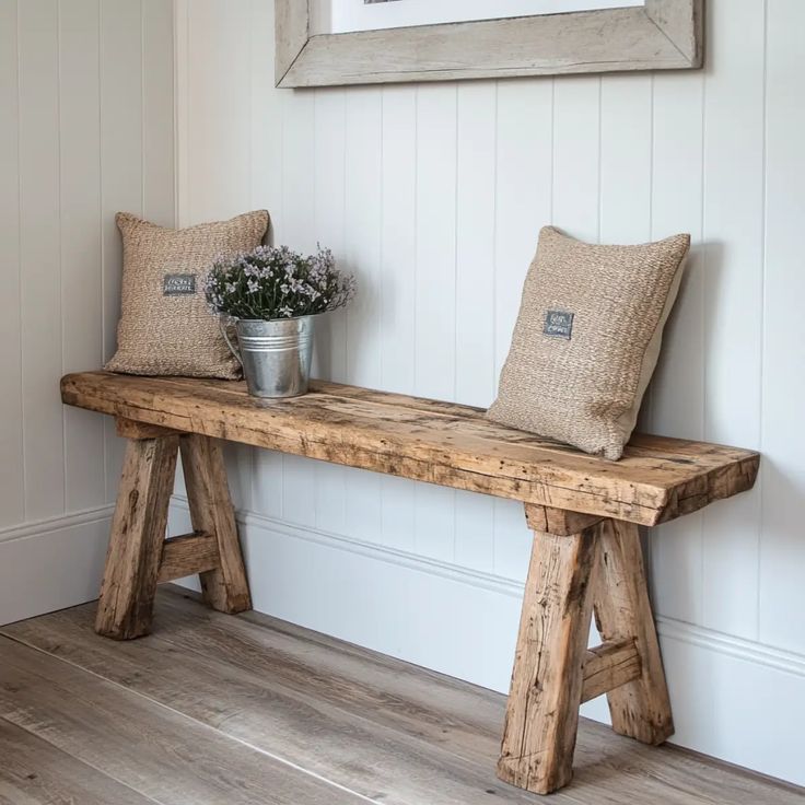 a wooden bench with two pillows on it and a potted plant next to it