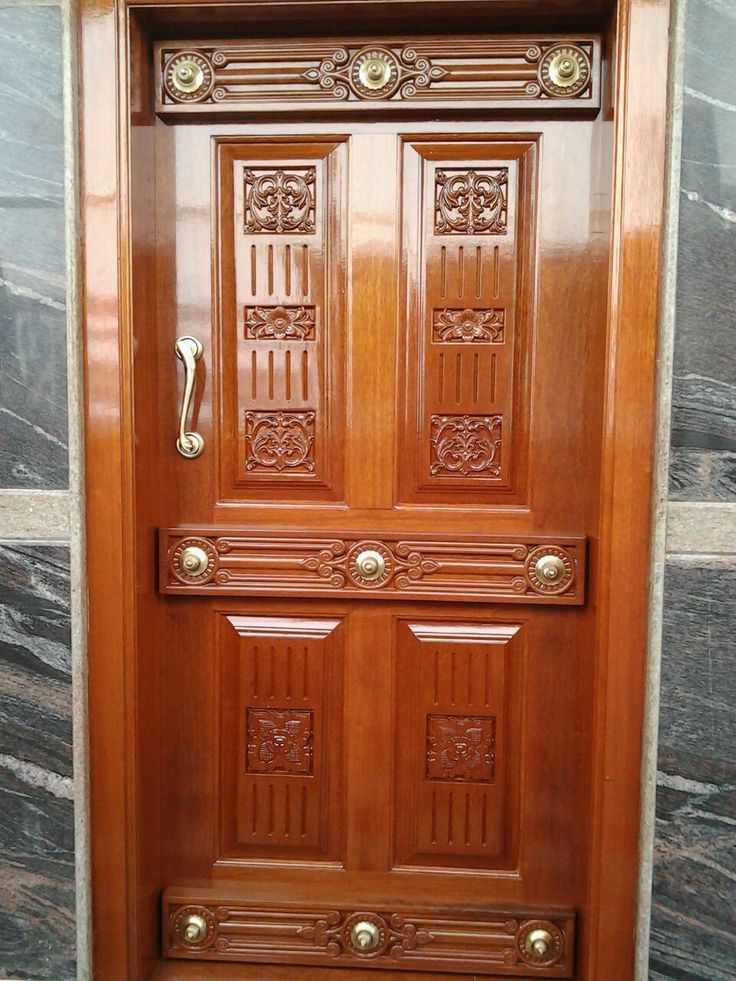 a wooden door with ornate carvings on the front and side panels, in a building