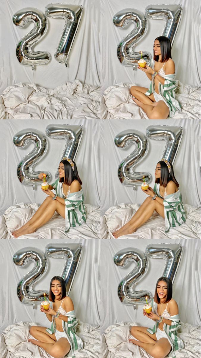 a woman laying on top of a bed next to a number two balloon in the air