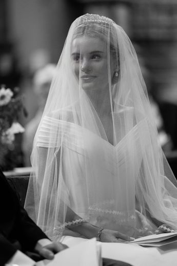 a woman sitting at a table with a veil over her head