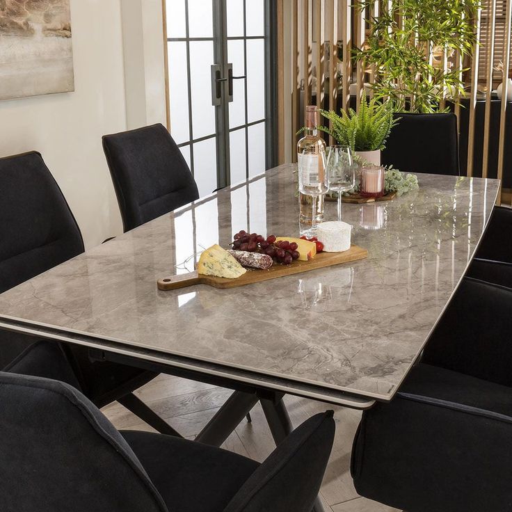 a table with wine and cheese on it in front of a glass door that leads to a balcony