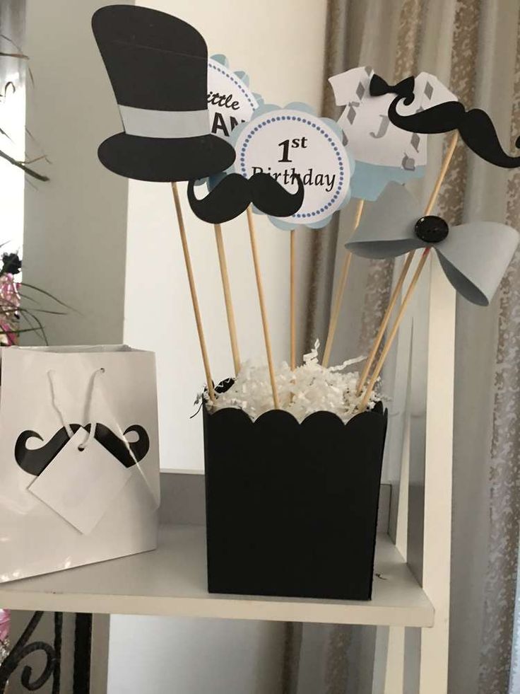 there is a black and white cake topper on the shelf next to some cupcakes