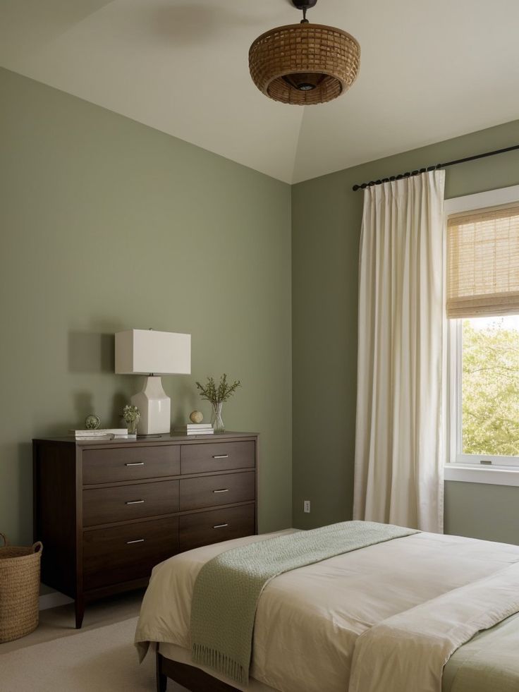 a bedroom with green walls and white curtains