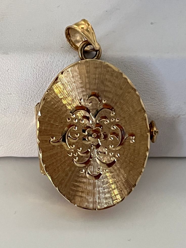 This hand-made oval locket is as sentimental and unique as it gets. It is a perfect Christmas or Hanukah. It is made of 14 karat gold. It is both beautiful and functional. Most lockets can hold 2 pictures but this one can hold 4 special photos close to your, or your loved one's heart! The photos are easy to slip through slots at top of locket. It is hard to match the workmanship of this locket and it's engraving. It was crafted by a very talented jeweler in the NYC jewelry district between 1970 - 1980. Lockets are his legacy and his remaining inventory is being sold on this site. Most are one of a kind and will not be available after it is sold. The best jewelers are in awe of the workmanship and you will always get compliments. This precious locket and can easily become a heirloom that ca Anniversary Filigree Yellow Gold Locket Necklace, Victorian Oval Locket Necklace With Intricate Design, Ornate Oval Locket Necklace For Wedding, Gold Oval Locket Necklace For Anniversary, Elegant Rose Gold Oval Locket Necklace, Formal Gold Oval Locket Necklace, Gold Oval Locket Necklace For Keepsake, Yellow Gold Round Filigree Locket Necklace, Yellow Gold Round Locket Necklace With Filigree