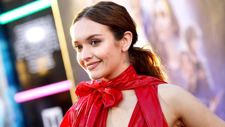 a woman in a red dress smiling at the camera