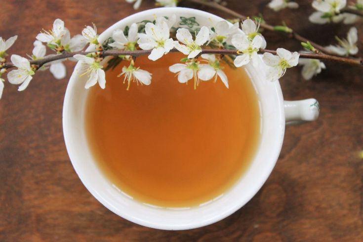 a cup of tea with white flowers in it