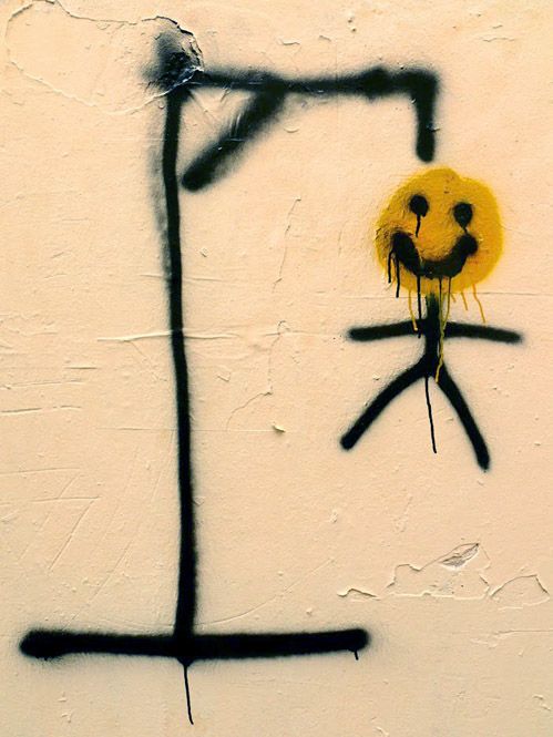 a yellow smiley face drawn on the side of a wall