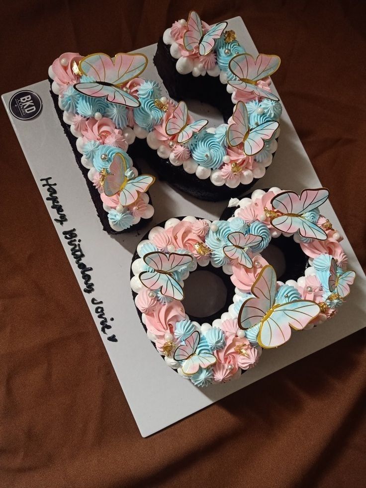 two decorated doughnuts sitting on top of a white card with pink and blue flowers