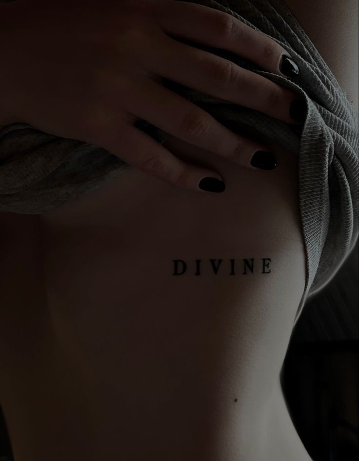 a woman's back with the word divine written on it