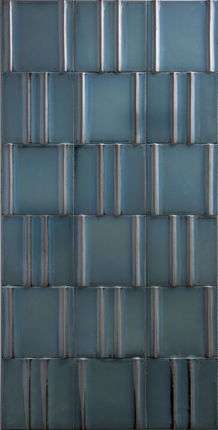 a blue tile wall that is made up of small squares and strips in different colors