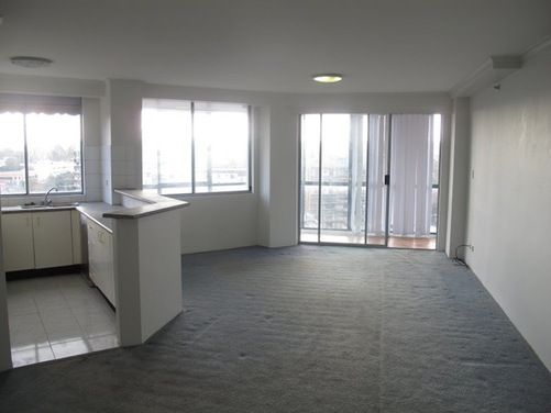 an empty living room and kitchen area with sliding glass doors