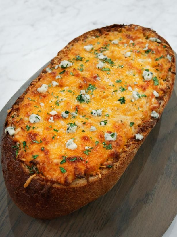 a cheesy bread dish on a wooden platter