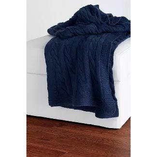 a blue blanket is sitting on top of a white couch