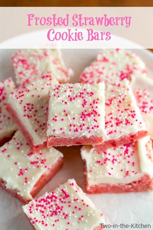 frosted strawberry cookie bars on a white plate with pink sprinkles in the middle