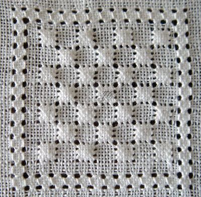 a white crocheted tablecloth with black dots on the edges and an openwork design