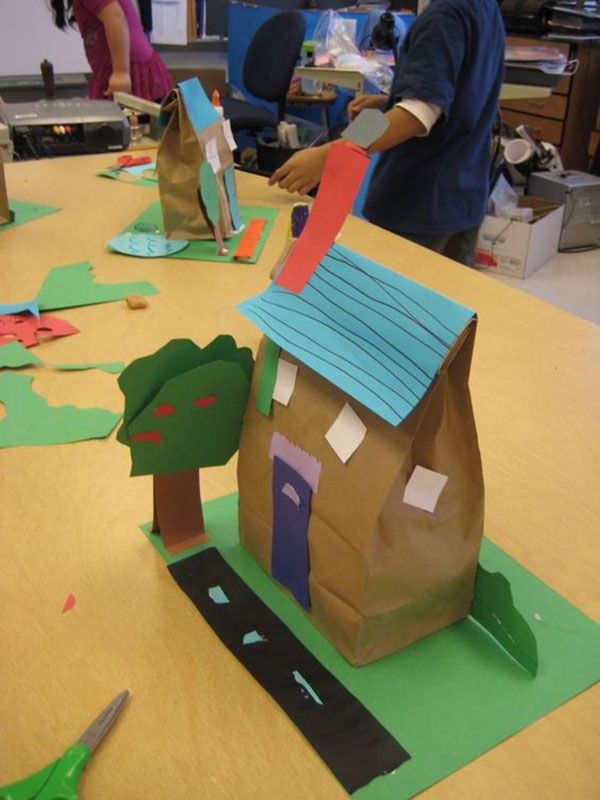 children are making paper houses on the table