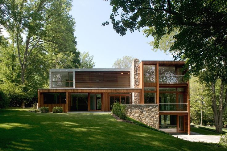 a modern house in the middle of a lush green field