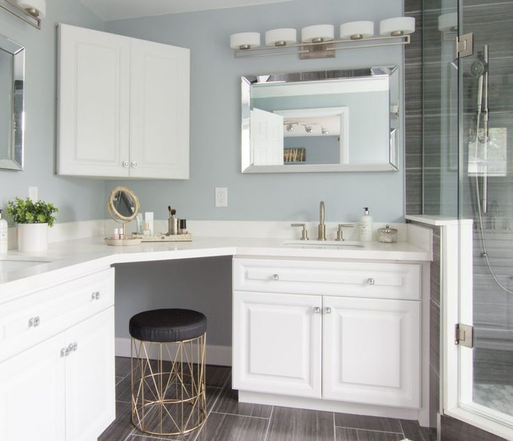 a bathroom with white cabinets and gray flooring