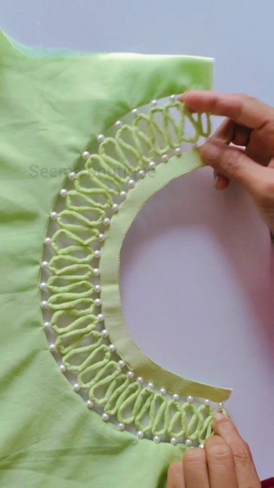 someone is working on a piece of clothing that has been made with yarn and beads