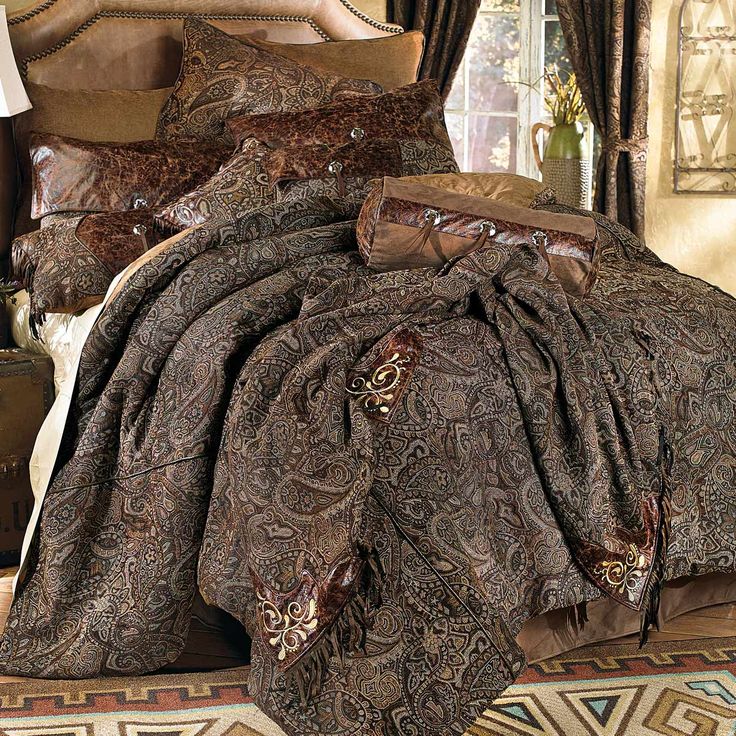 a bed covered in brown and black comforters