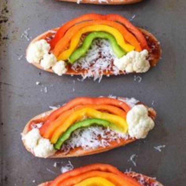 four hot dogs with different colored toppings on them