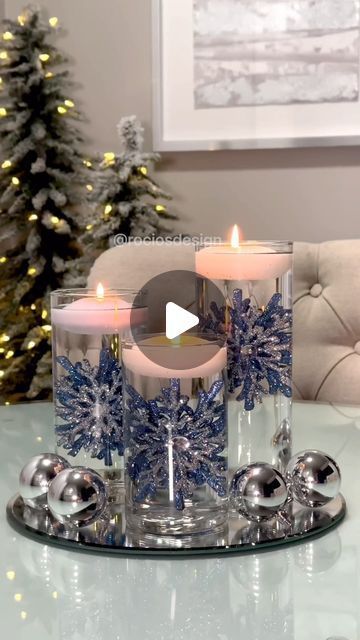 two candles sitting on top of a glass plate with snowflakes in the middle