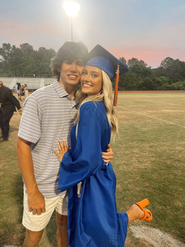 a man and woman in graduation gowns hugging each other