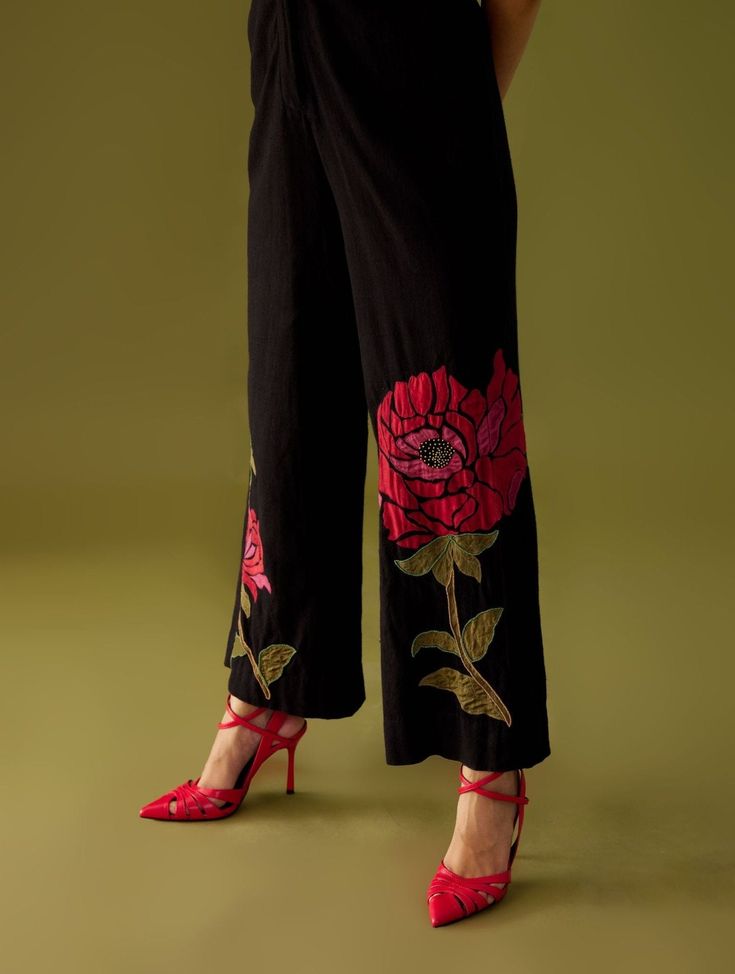 Editor's Note Black Kala Cotton Floral Applique Jumpsuit With Beadwork Ruffle Collar Color: Black Fabric: Cotton Care: Dry Clean Only About the Designer Chandrima celebrates diversity in cultures and craft forms creating ready-to-wear women wear for the urban woman of today. The brand embodies the idea of Indian handloom and craft merged with an international style. Label Chandrima stands for modern elegance and craftsmanship stemmed from the diversity and unity of the country. Traditional Party Bottoms With Resham Embroidery, Summer Festive Pants With Floral Embroidery, Summer Festive Floral Embroidery Pants, Festive Resham Embroidered Pants, Fitted Pants With Resham Embroidery For Spring, Spring Fitted Pants With Resham Embroidery, Black Festive Set For Summer, Black Embroidered Sets For Spring, Embroidered Black Sets For Spring