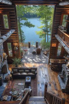 an aerial view of a living room with wood flooring and large windows overlooking the lake