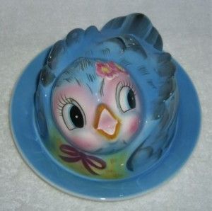 a blue bird sitting on top of a blue plate