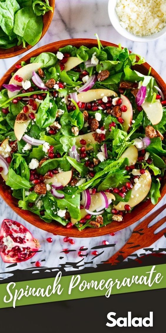 spinach pomegranate salad in a bowl on a marble table