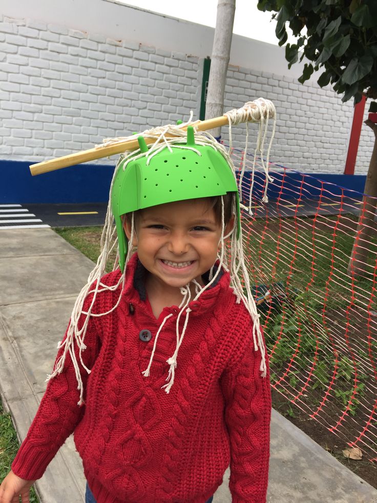 a young boy wearing a green hat and holding a baseball bat