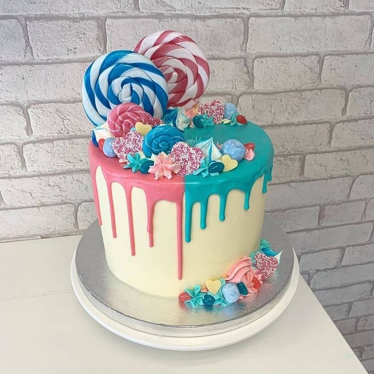 a colorful cake decorated with candy and lollipops