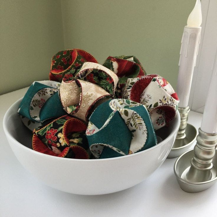 a white bowl filled with lots of fabric pieces