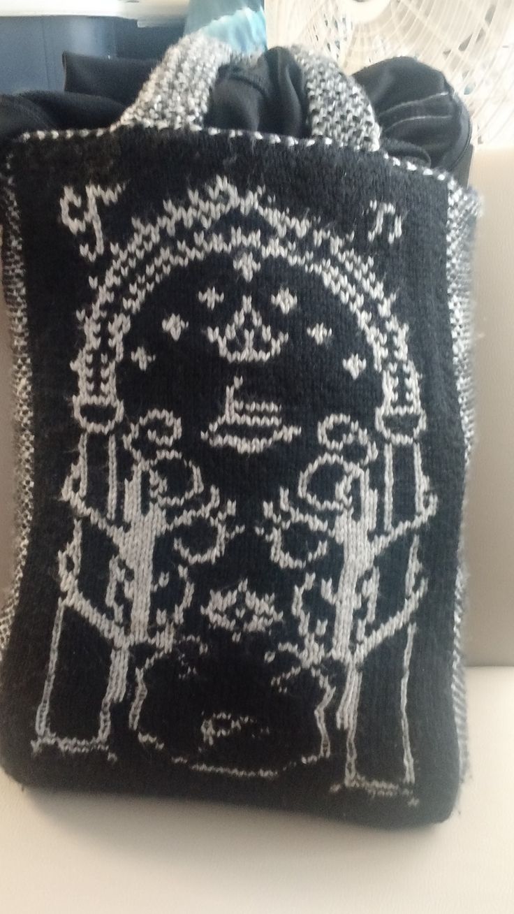 a black and white knitted bag sitting on top of a table