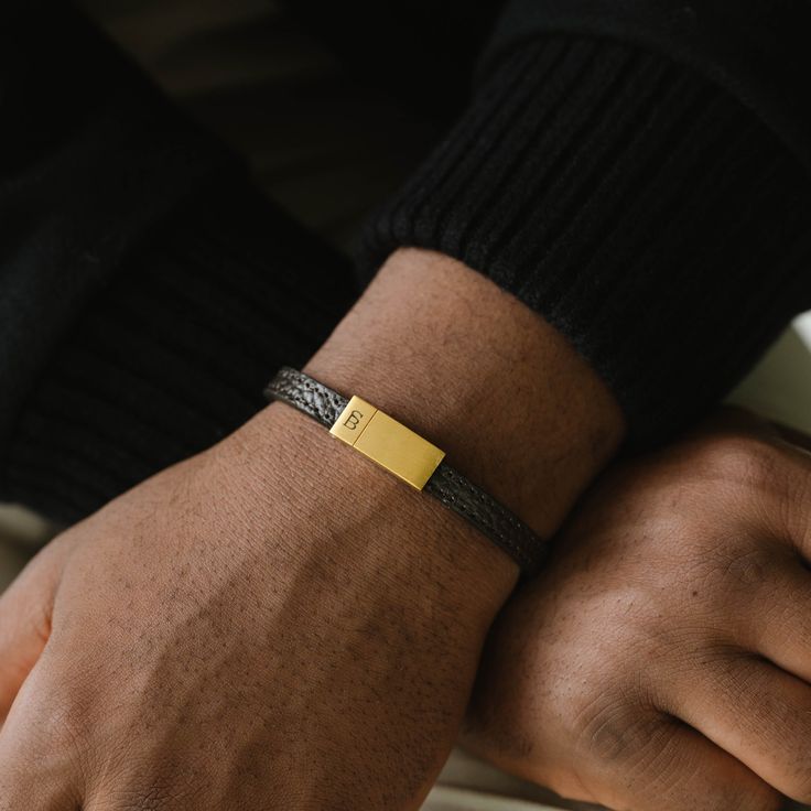 The Grady is a handmade bracelet featuring a slim cowhide leather strap. The design is comfortable, minimalist, straightforward, and stylishly refined.- WIDTH: 8 mm- MATERIAL TYPE: 100% genuine pebbled cowhide leather- CLASP COLOR: Brushed gold- CLASP MATERIAL: 316L stainless steel, 18K gold PVD plated- CLASP TYPE: Magnetic 99 Design, Gold Armband, Jewelry For Men, Bracelet Cuir, Black Edition, Handmade Bracelet, Leather Band, Handmade Bracelets, Cowhide Leather