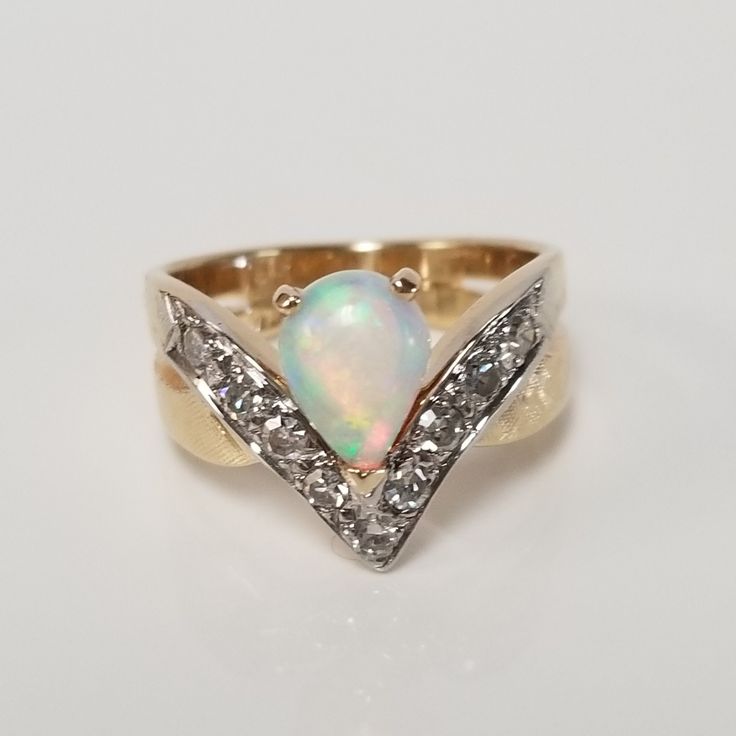 "Thanks for shopping our vintage estate store. We tend to sell well below wholesale and truly hope you enjoy all of our items. Many of the items are one of a kind, so please enjoy scrolling through the pictures and hopefully something will catch your eye. Brown spots are from the camera or reflections. Estate 14k yellow gold natural fire 1.5ct opal .50ct diamond ring. There are 9 diamonds and they are nice and bright. Ring size: 6 Setting: 1/4\" 7mm by 11mm 1/2\" Gem: 9mm by 6.5mm Band width: 4m Fine Jewelry Opal Ring With Multi-stone For Anniversary, Yellow Gold Multi-stone Opal Ring For Anniversary, Heirloom Multi-stone Opal Ring For Anniversary, Vintage Hallmarked Opal Ring For Anniversary, Oval Opal Ring Stamped 14k For Anniversary, Pear-shaped Vvs Clarity Rings For Anniversary, Pear-shaped Multi-stone Diamond Ring For Anniversary, Anniversary Opal Ring Stamped 14k In Oval Shape, Pear-shaped Multi-stone Diamond Anniversary Ring