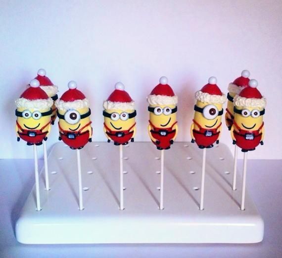 six minion lollipops with santa hats on them sitting on a white tray