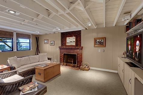 a living room filled with furniture and a flat screen tv mounted on a wall next to a fire place