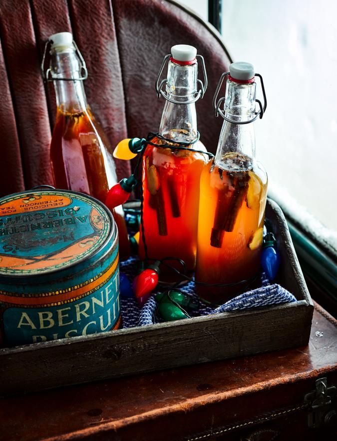 three bottles of alcohol sitting on top of a wooden box next to a canister