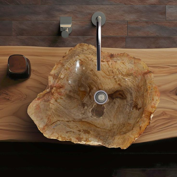 a bathroom sink made out of wood on top of a wooden counter next to soap dispenser