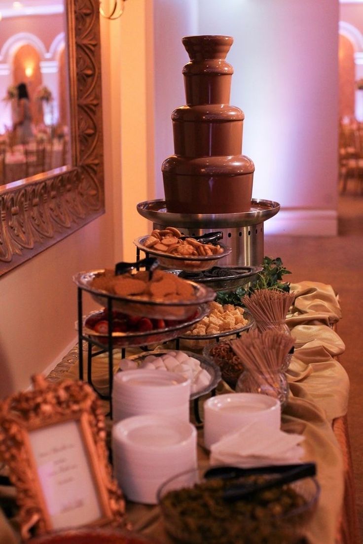 a buffet table filled with lots of food and desserts on top of each other