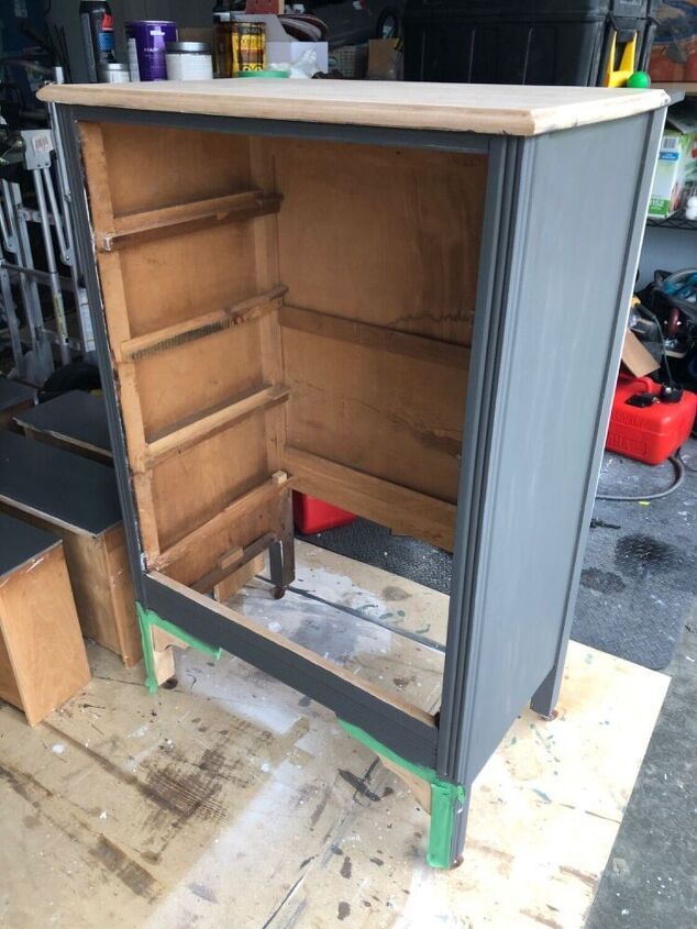 an open cabinet sitting on top of a hard wood floor next to other boxes and tools